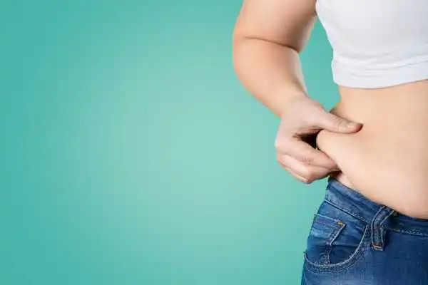 Image of woman pinching her love handles to show weight gain Didcot